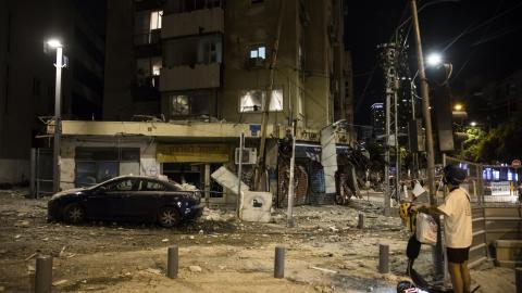 A man passes the scene where a rocket fired from Gaza strip hit a building on October 7, 2023, in Tel Aviv, Israel. (Photo by Amir Levy via Getty Images)