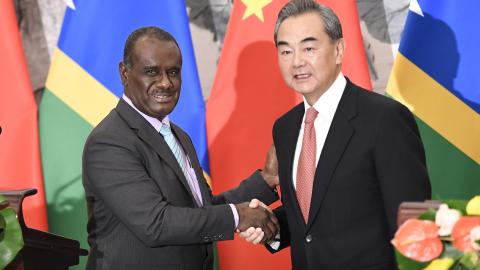 Solomon Islands Foreign Minister Jeremiah Manele shakes hands with Chinese Foreign Minister Wang Yi to mark the establishment of diplomatic ties between the two nations in September, 2019 in Beijing, China. (Naohiko Hatta via Getty Images)
