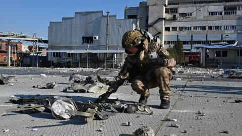 A Ukrainian law enforcement officer inspects the remains of a missile in front of a destroyed perfume and cosmetics manufacturing building following an attack in Kharkiv, Ukraine, on April 18, 2025. (Getty Images)