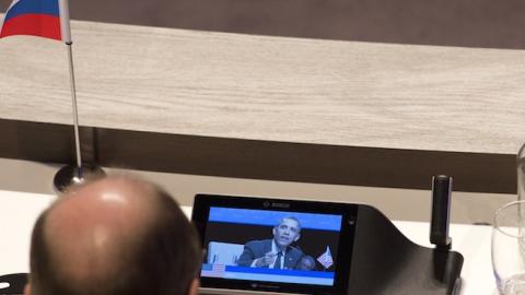A member of Russia's delegation looks at a monitor showing the speech of US President Barack Obama during the Nuclear Security Summit in The Hague on March 25, 2014. (SAUL LOEB/AFP/Getty Images)