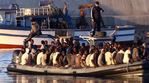 Sub-Saharan African migrants are rescued by the Libyan coastguard after their inflatable boat started to sink off the coastal town of Guarabouli, November 20, 2014. There were 108 people rescued from the sinking raft. (MAHMUD TURKIA/AFP/Getty Images)