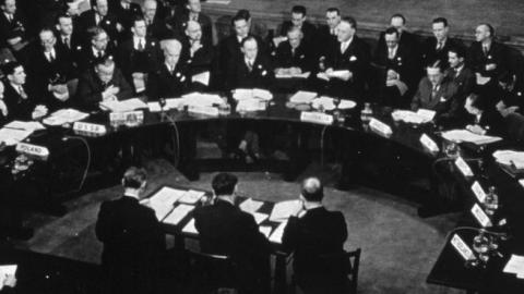 Delegates at the first session of the UN Security Council Council sit round a half moon table attended by officials, January 17, 1946. (MPI/Getty Images)