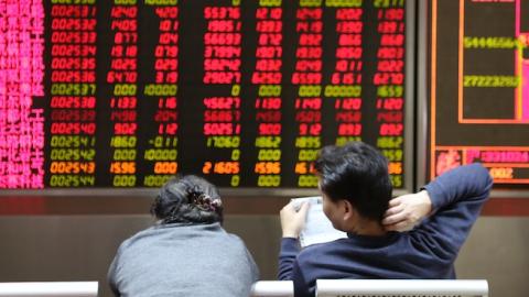Investors observe stock market at an exchange hall on January 6, 2016 in Beijing, China. (ChinaFotoPress/Getty Images)