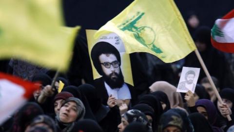 Supporters wave the flag of Lebanon and the Shiite movement Hezbollah alongside a poster of former Hezbollah leader Abbas al-Mussawi during a rally in Beirut on February 16, 2016. (ANWAR AMRO/AFP/Getty Images)