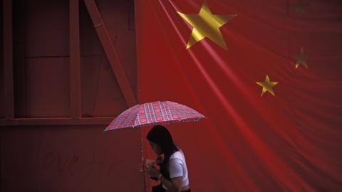 A Chinese flag hangs over a pedestrian in Hong Kong. (Richard Baker / In Pictures via Getty Images)