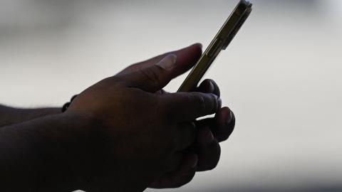 A man uses an Apple iPhone in Beijing on September 12, 2023. (Photo by Pedro Pardo/AFP via Getty Images)