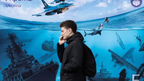 People walk past a poster depicting Russian warships sunk by Ukrainian attacks in the Black Sea on March 16, 2024, in Kyiv, Ukraine. (Photo by Oleksii Chumachenko/Global Images Ukraine via Getty Images)
