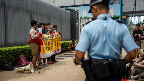 A police officer looking at League of Social Democrats protesting outside the Central Government office on October 25, 2023, in Hong Kong, China. (Vernon Yuen via Getty Images)