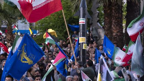 Men wave Iranian flags and flags of the Islamic Revolutionary Guard Corps at a gathering to celebrate the IRGC attack against Israel in Tehran, Iran, on April 15, 2024. (Photo by Morteza Nikoubazl/NurPhoto via Getty Images)