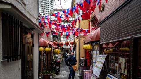 A man stands under Taiwanese flags on a street in the Chinatown section of Yokohama, Kanagawa prefecture, south of Tokyo on January 28, 2024. (Photo by Philip FONG / AFP) 