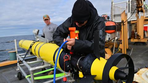 U.S. Navy members assigned to Unmanned Undersea Vehicle Flotilla 1 conduct troubleshooting and maintenance measures on the Razorback UUV before it is launched for an exercise aboard U.S. Coast Guard Cutter Forward (WMEC 911) in the Atlantic Ocean, Aug. 26, 2023.