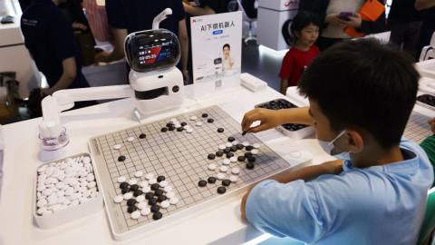 SHANGHAI, CHINA - JULY 6, 2023 - A Yuanradish chess robot displayed by SenseTime plays Go with a child at the 2023 World Artificial Intelligence Conference in Shanghai, China, July 6, 2023. (Photo credit should read CFOTO/Future Publishing via Getty Images)