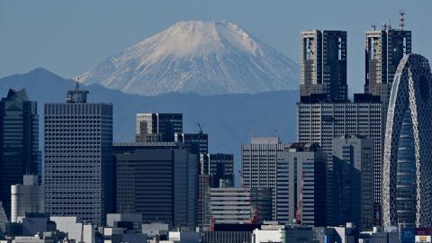 This picture taken on November 14, 2023 shows Japan's highest mountain, Mt. Fuji in the background between skyscrapers in Tokyo's Shinjuku area. (Photo by Kazuhiro NOGI / AFP) (Photo by KAZUHIRO NOGI/AFP via Getty Images)