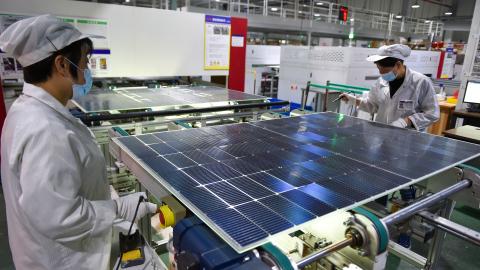 A worker is producing photovoltaic panel components at a workshop of a photovoltaic enterprise in Suqian, Jiangsu Province, China, on December 9, 2023. (Photo by Costfoto/NurPhoto via Getty Images)