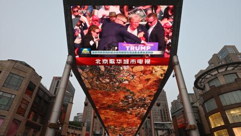 A news program about the assassination attempt on former President Donald Trump is being watched at a shopping mall in Beijing on July 14, 2024. (Greg Baker/AFP via Getty Images)