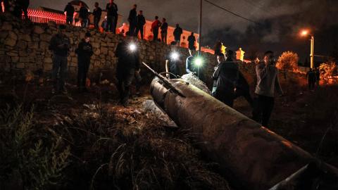 Palestinian youths inspect a fallen projectile after Iran launched a barrage of missiles at Israel in the occupied West Bank on October 1, 2024. (Zain Jaafar/AFP via Getty Images)