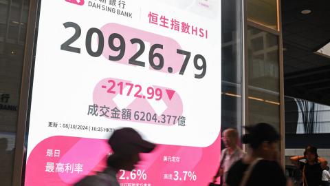 Pedestrians walk past a sign showing the numbers of the Hang Seng Index in Hong Kong on October 8, 2024. Hong Kong stocks plunged more than nine percent on October 8, their biggest fall in 16 years, after China left investors disappointed by a lack of new stimulus and few details about measures announced last month. (Photo by Peter PARKS / AFP) (Photo by PETER PARKS/AFP via Getty Images)