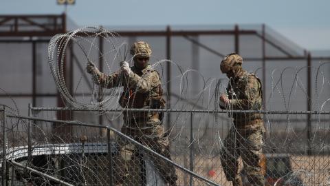 Border patrol officers pull barbed wires as irregular immigrants coming from Central and South America who have gathered in the town of Ciudad Juarez on the Mexican border continue to wait at the US border on March 20, 2024, in Ciudad Juarez, Mexico. (Photo by Christian Torres/Anadolu via Getty Images)