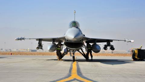 An F-16 pilot prepares for takeoff while airmen perform final preflight inspections on January 9, 2015, at Bagram Air Field in Afghanistan. (US Air Force)