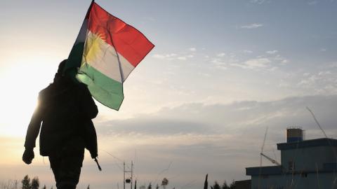 A Peshmerga soldier walk to place a Kurdish flag near the frontline with ISIL on November 16, 2015 in Sinjar, Iraq. (John Moore/Getty Images)
