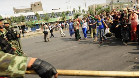 Ethnic Uyghur women protest towards Chinese riot police in Urumqi in China's far west Xinjiang province on July 7, 2009. (PETER PARKS/AFP/Getty Images)