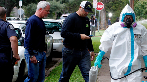 A man dressed in protective hazmat clothing leaves after treating the front porch and sidewalk of an apartment where a second person diagnosed with the Ebola virus resides on October 12, 2014 in Dallas, Texas. (Mike Stone/Getty Images)