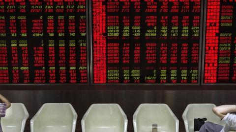 Chinese day traders watch stock tickers at a local brokerage house on August 27, 2015 in Beijing, China. (Kevin Frayer/Getty Images)