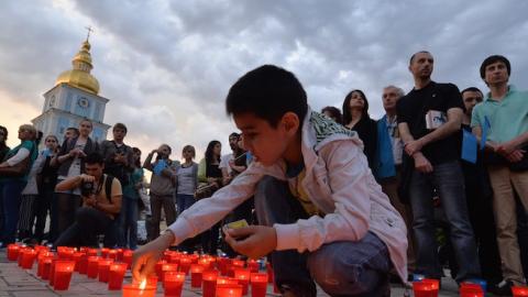 A Crimean Tatar boy lights a candle during a memorial ceremony in Kiev on May 17, 2014, held on the 70th anniversary of the deportation of Tatars from Crimea. (SERGEI SUPINSKY/AFP/Getty Images)