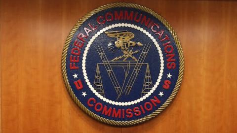 The seal of the Federal Communications Commission hangs behind commissioner Tom Wheeler's chair inside the hearing room at the FCC headquarters February 26, 2015 in Washington, DC. (Mark Wilson/Getty Images)