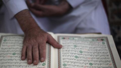 A mourner reads the Quran on August 17, 2011 in Gaza City, Gaza. (Christopher Furlong/Getty Images)