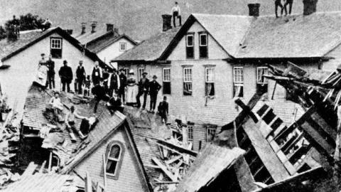 People stand atop a mass of destroyed houses that had been compressed by the force of floodwaters on May 31, 1889. (National Park Service)