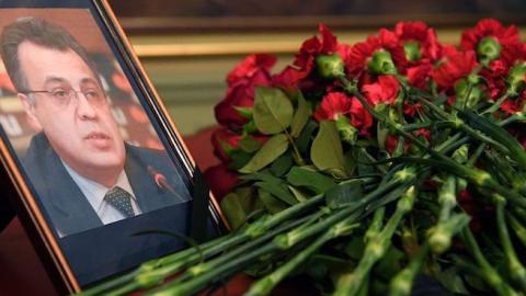 Flowers are placed in front of a portrait of Russian Ambassador to Turkey Andrei Karlov in the Foreign Ministry in Moscow on December 20, 2016, a day after his assassination in the Turkish capital. (NATALIA KOLESNIKOVA/AFP/Getty Images)