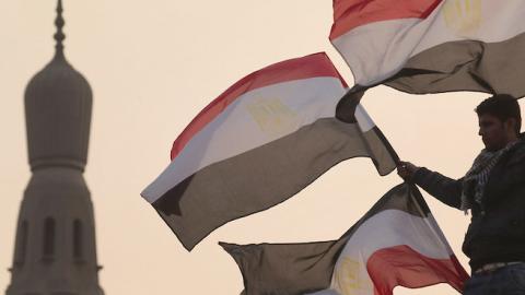 A youth waves Egyptian flags from a lamp post in Tahrir Square on February 1, 2011 in Cairo, Egypt. (Peter Macdiarmid/Getty Images)