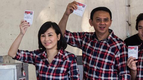 Basuki Tjahaja Purnama and his family show their ballot after voting in the Jakarta Governal Election on February 15, 2017 (Oscar Siagian/Getty Images)