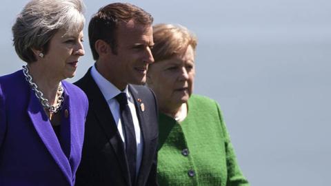 British Prime Minister Theresa May, French President Emmanuel Macron, and German Chancellor Angela Merkel arrive for a family photo during the G7 Summit in in La Malbaie, Quebec, Canada, June 8, 2018. (Photo by GEOFF ROBINS / AFP) (Photo credit should rea
