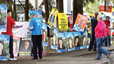 Campaign signs are seen outside the entrance to a voting center at the Homebush West Community center on May 10, 2022 in Sydney, Australia. (Photo by Mark Kolbe/Getty Images)