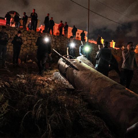 Palestinian youths inspect a fallen projectile after Iran launched a barrage of missiles at Israel in the occupied West Bank on October 1, 2024. (Zain Jaafar/AFP via Getty Images)