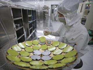 An employee processes chips at a workshop of Jiangsu Aoyang Shunchang Photoelectric Technology Co., Ltd. on May 11, 2024 in Huaian, Jiangsu Province of China. (Photo by Zhao Qirui/VCG via Getty Images)