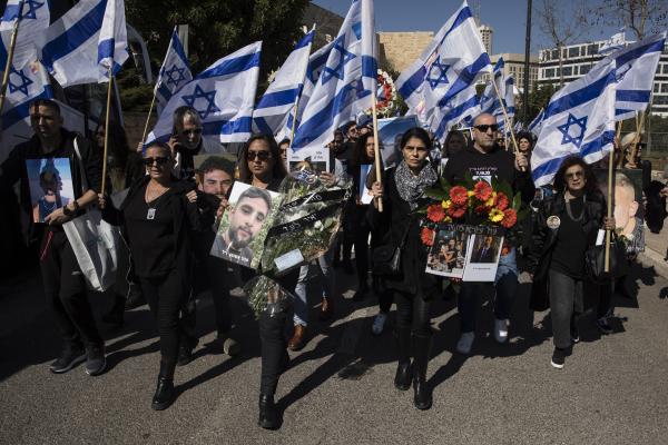 People walk with photos of people killed on the October 7 Hamas attack on Israel's south during a memorial event held by families of victims on February 7, 2024, in Jerusalem, Israel. (Amir Levy via Getty Images)