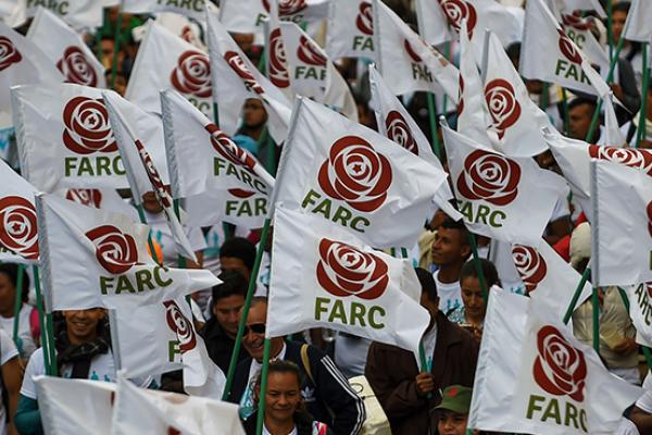 FARC members and supporters wave flags with the new logo of the rebaptized FARC following its disarmament, September 1, 2017 (RAUL ARBOLEDA/AFP/Getty Images)