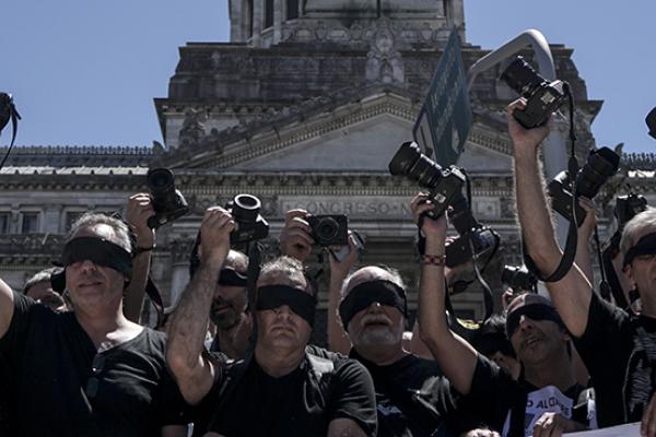 Photojournalists raise their cameras as a protest against the closure of Argentine private news agency DYN in Buenos Aires, November 14, 2017 (EITAN ABRAMOVICH/AFP/Getty Images)
