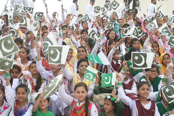 Pakistani girls hold Pakistani flags during a ceremony marking Pakistan's 69th Independence Day, August 14, 2016 