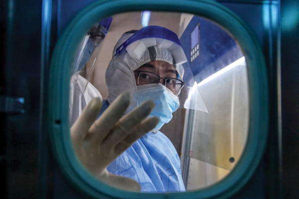  A medical staff member gestures inside an isolation ward at Red Cross Hospital in Wuhan in China's central Hubei province on March 10, 2020. (Photo by STR/AFP via Getty Images)