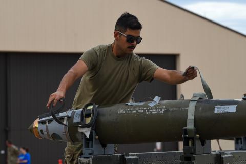 An airman unstraps an inert Joint Direct Attack Munition (JDAM) during the Lone Star Challenge at Dyess Air Force Base, Texas, on July 13, 2023. (US Air Force photo)