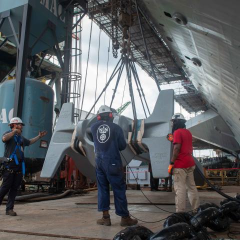 Newport News Shipbuilding contractors lift the starboard anchor of the Nimitz-class aircraft carrier USS John C. Stennis in Newport News, Virginia, on July 14, 2023. (US Navy photo)